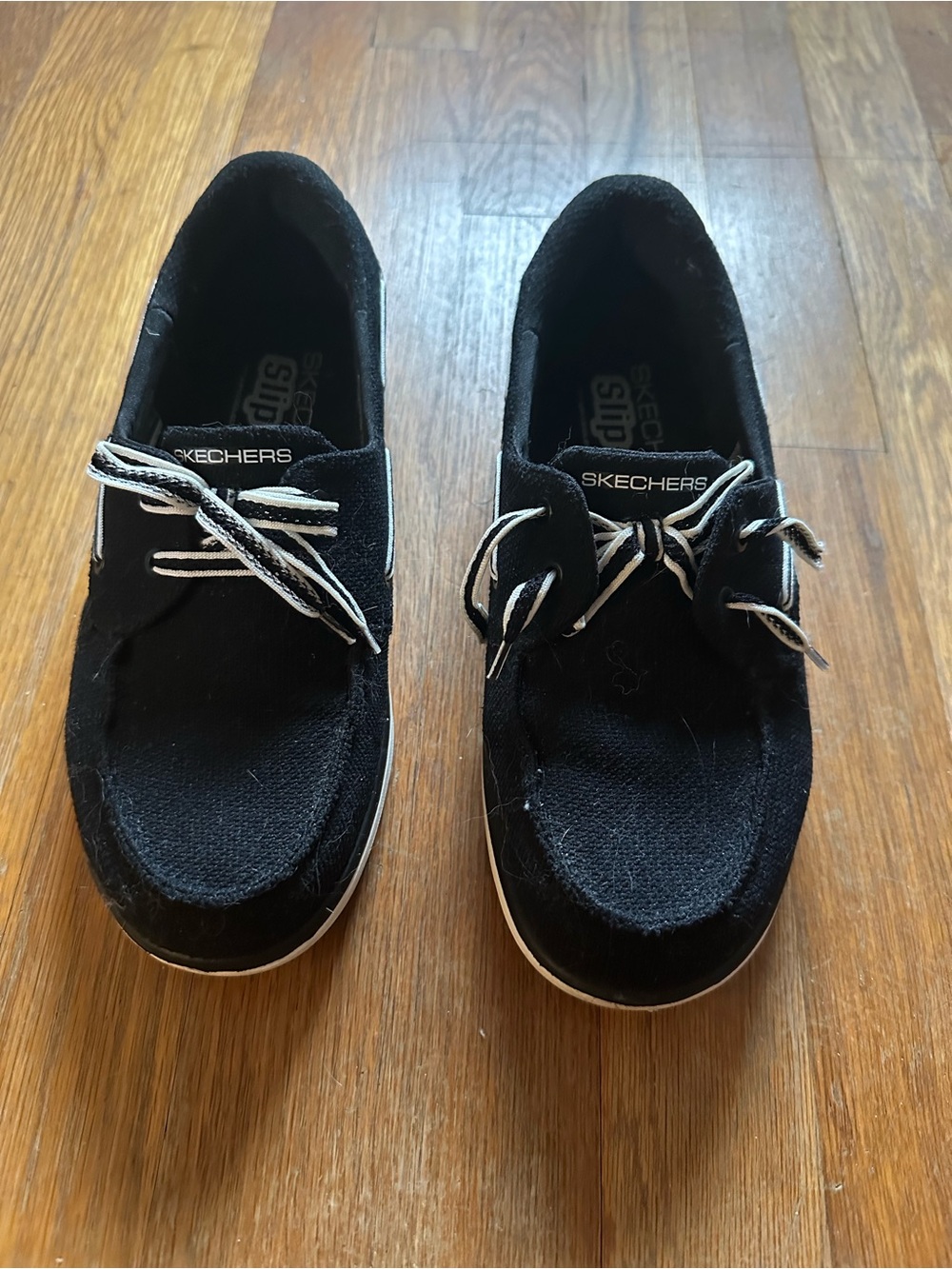 Skechers Woman’s  Black Slip-On Sneakers with White Trim
